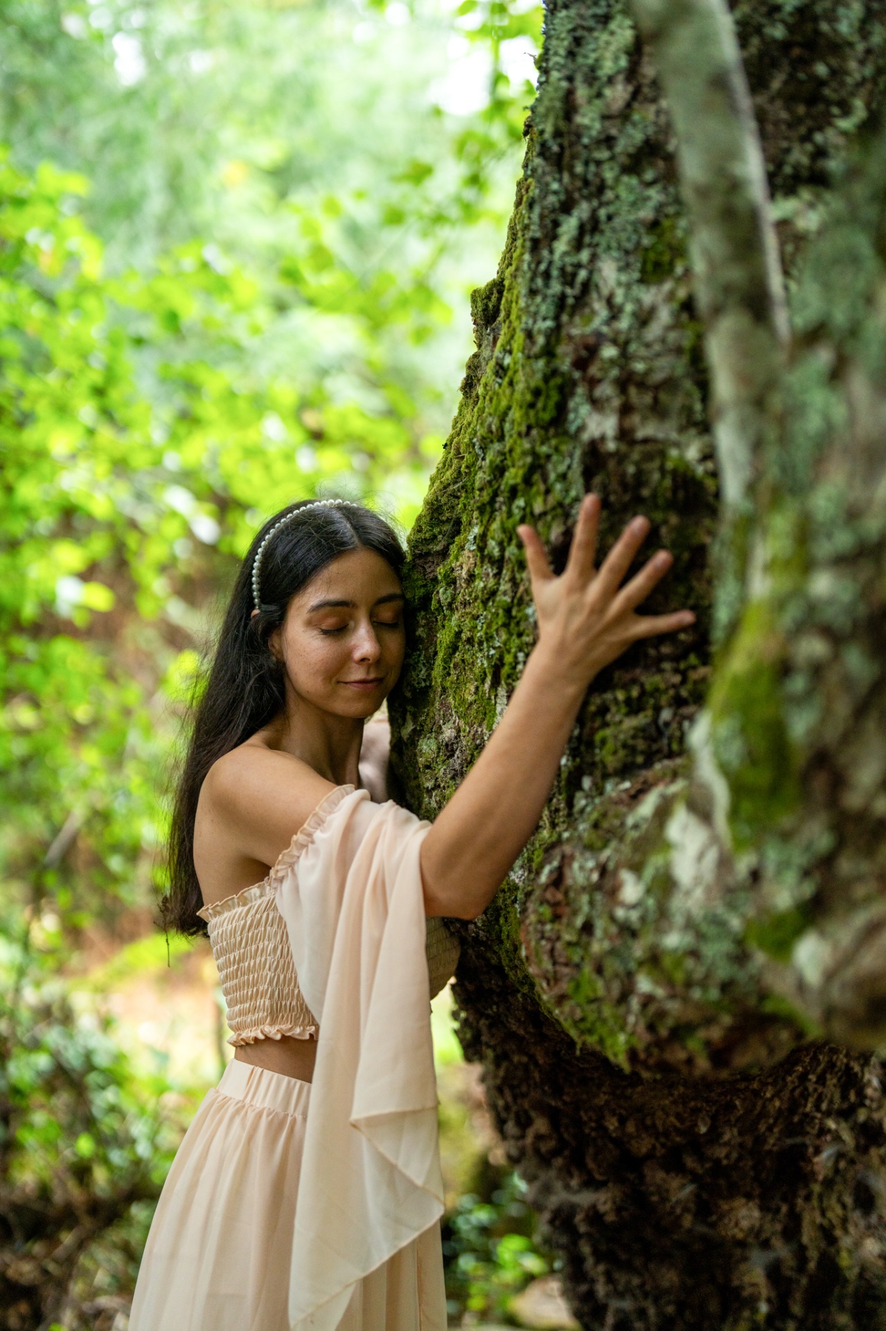 Mulher em comunhão com uma árvore na floresta
